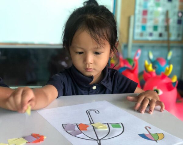 Preschool girl makes art at school